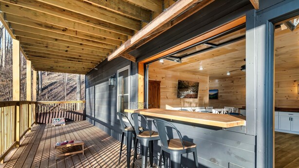Una terraza de madera con una barra y asientos.