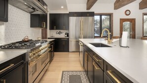 Una cucina moderna con elettrodomestici in acciaio inossidabile, mobili scuri e una grande isola.
