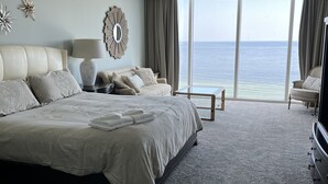 A spacious bedroom with a large bed, a ceiling fan, and a view of the ocean. - Mediterranean 802E Beautiful-Gulf-front-4BR 4.5BA-Exquisite Views FloraBama (Pensacola)