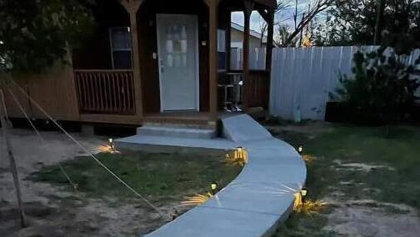 A curved pathway in a residential area with a house in the background. - Vibes Cowboy: Three (Marfa)