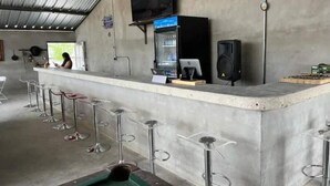 A bar area with a counter, stools, a television, and a speaker. - Vibes Cowboy: Quatro (Marfa)