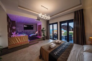 A hotel room with a bed, a massage area, a TV, and a balcony with a view. - SUITE APARTMENT TAORMINA (Taormina)