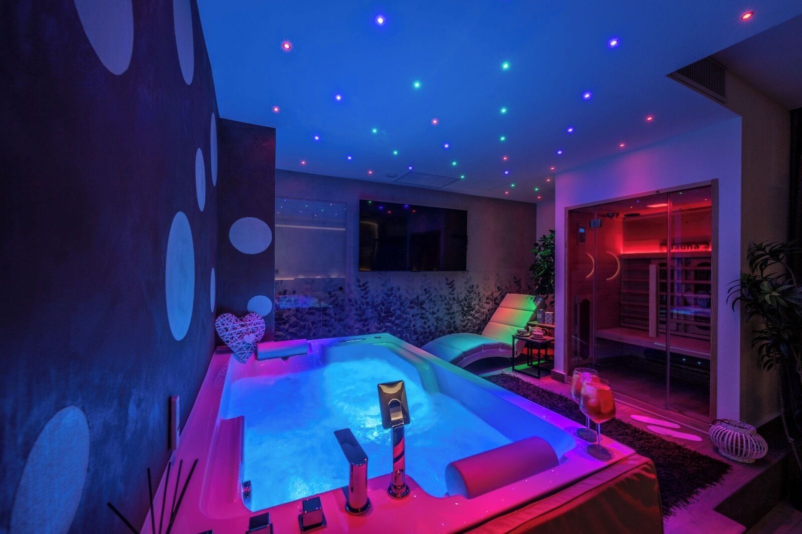Un cuarto de spa con hidromasaje, sillón de masaje e iluminación ambiental.