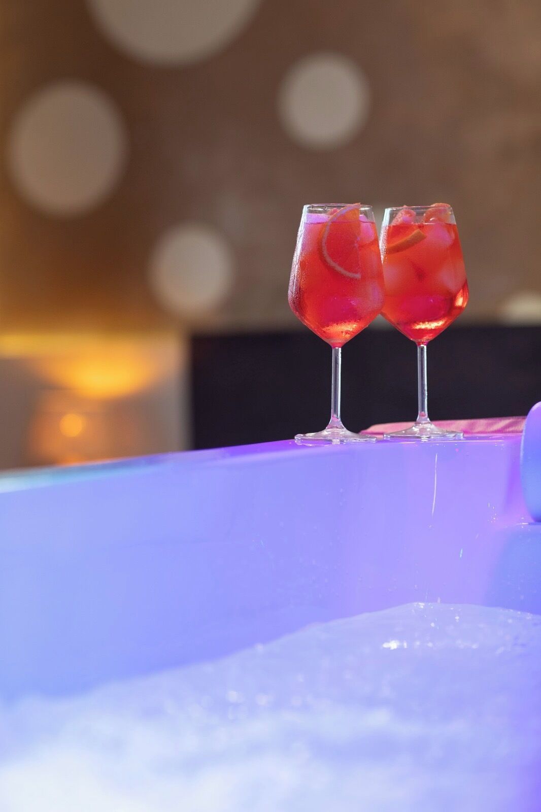 Two glasses of a red beverage on a table with a blurred background.