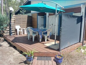 Relax on the patio surrounded by lush greenery and enjoy meals under the shade of a large umbrella.