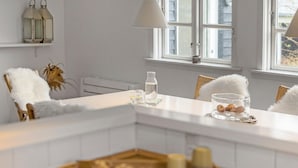 A modern kitchen with white cabinetry, a window with a view, and a white countertop with a water bottle and glass. - Amazing home in Hornbæk with WiFi (Hornbæk)