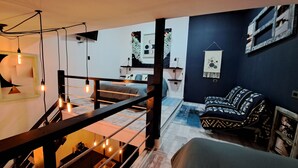 A modern interior with a staircase, a bed, a sofa, and a wall-mounted TV. - Okeyloft Coyhaique 2 (coyhaique)