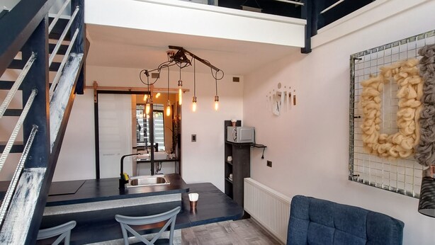 A modern interior with a staircase, dining area, and seating. - Okeyloft Coyhaique 2 (coyhaique)