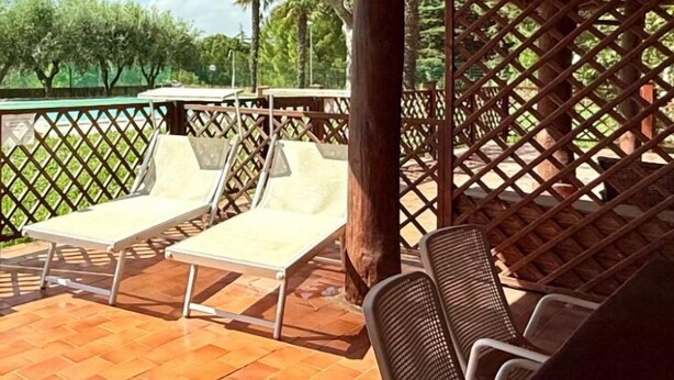 A covered outdoor seating area with lounge chairs and a wooden pergola. - VIVA2 - Numana, four-room apartment in villa with swimming pool (Numana)