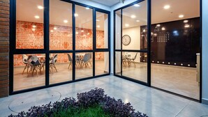 A modern interior with glass walls, a brick wall, and a clock on the wall.