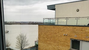 Un edificio moderno con fachada de ladrillo, amplias ventanas y vistas a un cuerpo de agua.