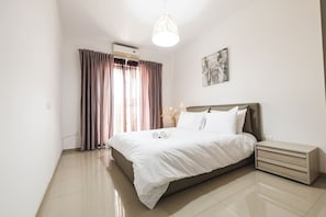 Une chambre à coucher moderne avec un lit, des tables de chevet et un luminaire au plafond.