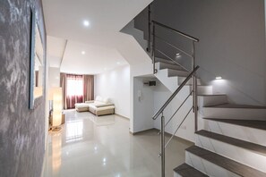 A modern interior with a staircase, a sofa, and a lamp. - Spacious 2 bedroom apartment (Il-Kalkara)