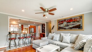A living room with a sectional sofa, a white coffee table, and a ceiling fan.