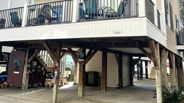 A two-story building with a balcony on the upper floor, a 'Welcome' sign, and a number '1026' on the side.