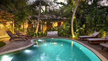 Una piscina al aire libre, sillones reclinables de piscina