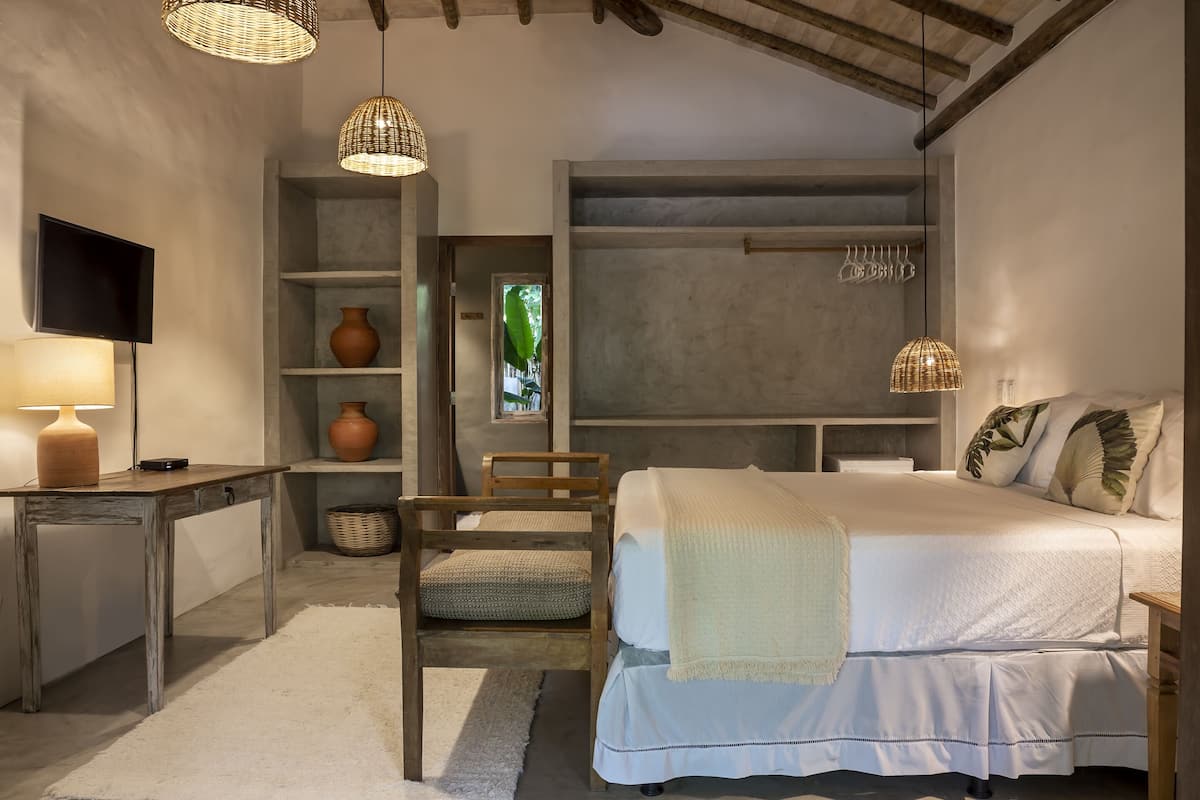 Une chambre à coucher comprenant un lit, un bureau, une chaise et un téléviseur.