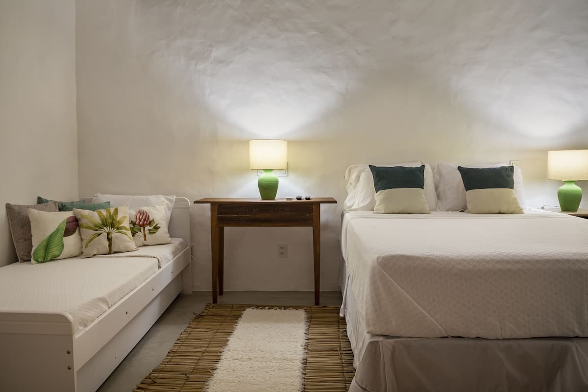 Une chambre à coucher avec un lit, une table de chevet et une lampe.