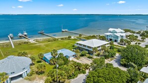 A coastal residential area with houses, a pier, and boats. - Sunset Vista | Private Dock, Dog-Friendly Home | My Beach Getaways (Pensacola Beach)
