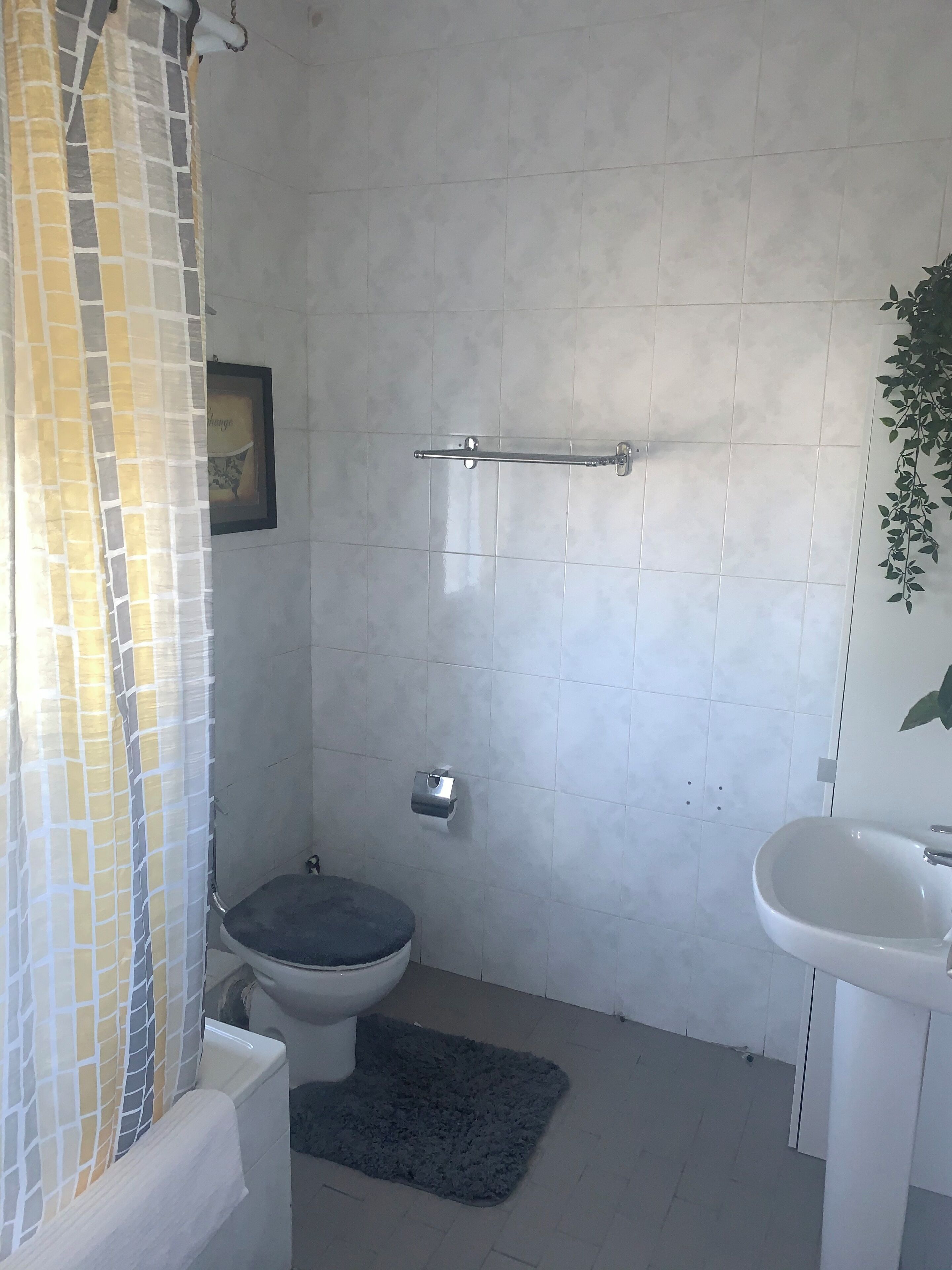 Une salle de bain avec des toilettes, une douche et un lavabo.