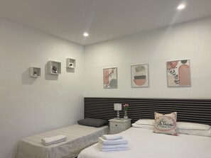 A modern bedroom with a bed, bedside tables, and wall-mounted shelves.