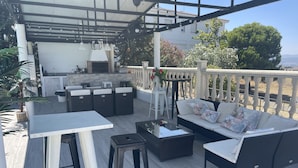 An outdoor patio area with a bar, seating, and a grill. - Villa Preciosa (Méntrida)