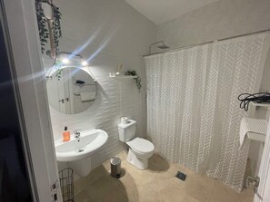 A bathroom with a sink, toilet, and shower curtain.