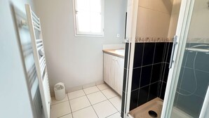 Ein Badezimmer mit Toilette, Waschbecken und Duschbereich.