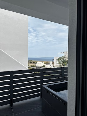 Ein Balkon mit Blick auf das Meer und Gebäude.