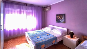 A bedroom with a bed, a nightstand, an air conditioner, and a painting on the wall. - Amazing apartment in Grizane with WiFi (Grizane)