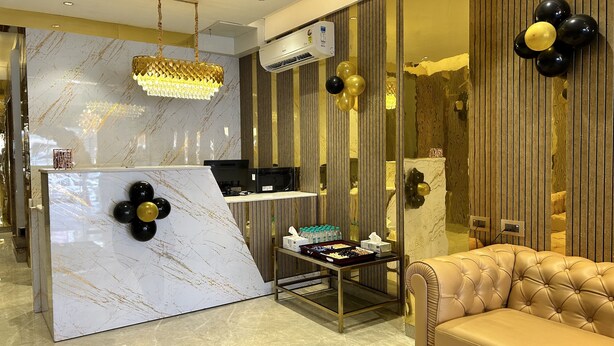 A modern interior with a marble reception desk, a leather sofa, and decorative balloons. - Nexstay Kites Inn (Bengaluru)
