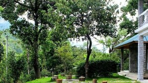 A stone pathway leading to a building with a stone facade. - Nexstay Ministers Mansion (Devikolam)