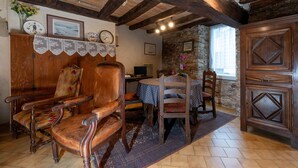 Une pièce rustique, avec des meubles en bois, un mur en pierre et un plafond en bois.