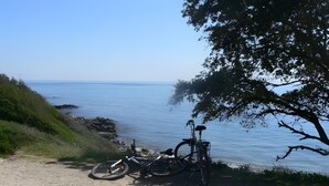 Een fiets geparkeerd op een zandpad langs het water.