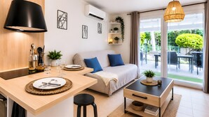 Et moderne køkken med spiseplads, sofa og udsigt til terrassen.