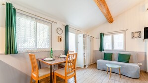 Ein Zimmer mit Esstisch, Stühlen, einer Couch und einem kleinen Tisch.