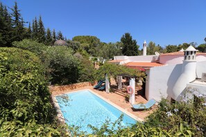 A swimming pool surrounded by greenery, a white building with a red roof, and a bell tower. - Villa 'La Perla' with Mountain View, Private Pool and Wi-Fi (Carvoeiro)