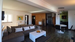 Un salon moderne avec un canapé, une table basse et un coin repas.