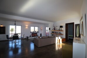 Un amplio salón con sofá, mesa de comedor, sillas y televisor.