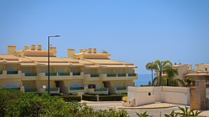 A multi-story hotel with balconies, a street lamp, and a view of the sea. - Apartment 'Casa Barbara' with Sea View, Shared Pool and Wi-Fi (Alporcinhos)
