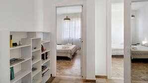 A hotel room with a bed, a bedside table, a wardrobe, and a bookshelf. - Seafront Apartment 'Fronte Mare - Marina Di Andora' with Balcony, Wi-Fi & Air Conditioning (Marina di Andora)