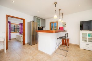 A modern kitchen with a central island, stainless steel appliances, and pendant lighting.