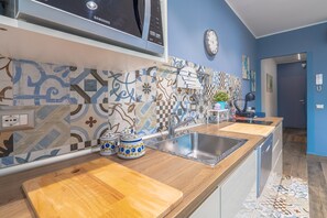 Una cocina moderna con microondas, pileta doble y encimeras de madera.