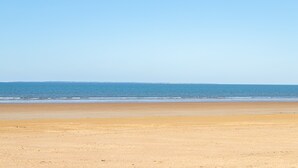 Een strand met een heldere lucht en rustige zee.