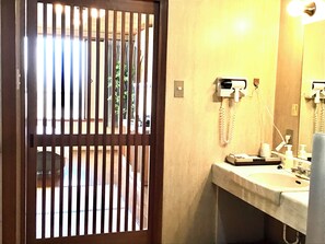 A bathroom with a sink, mirror, and telephone. - Hotel Sanda (Kobe)