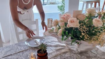 Una mesa dispuesta con un centro de mesa floral, una vela y un plato con servilleta.