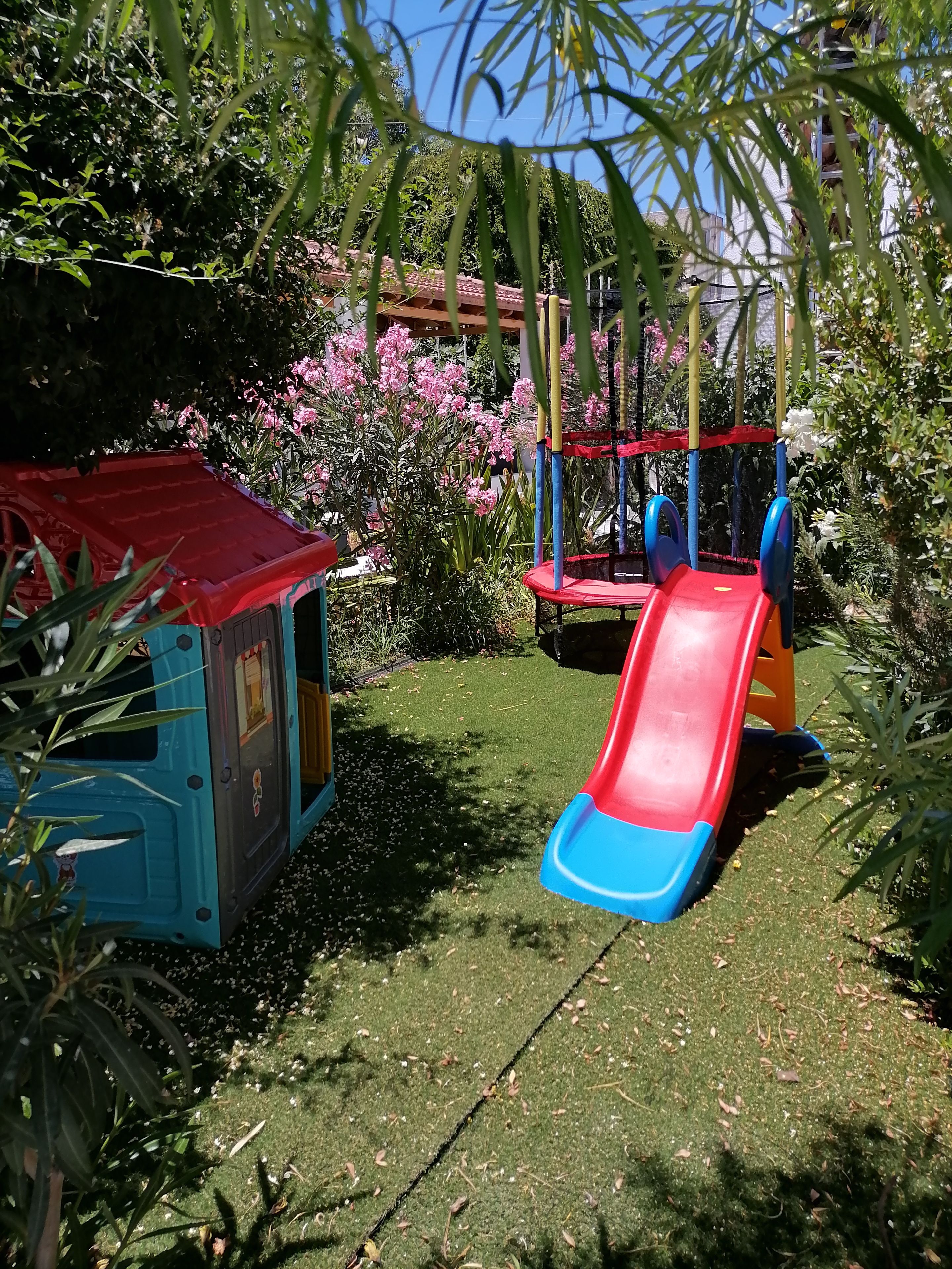 Ein Spielplatz mit einer Rutsche und einem kleinen Spielhäuschen.