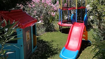 Un parque infantil con un tobogán y una casita de juegos.