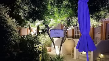 Vista nocturna de un patio de hotel con un letrero que indica una zona de juegos.