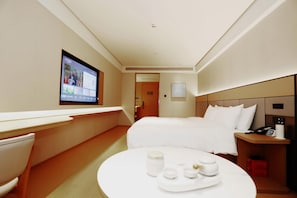 Relax in a stylish room with a made bed, bedside table, and flat-screen TV.